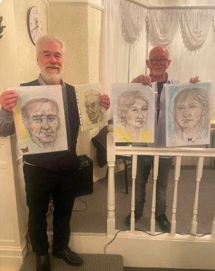Stephen Cavis and Billy McBrush holding spirit art portraits at Bury Spiritualist Centre